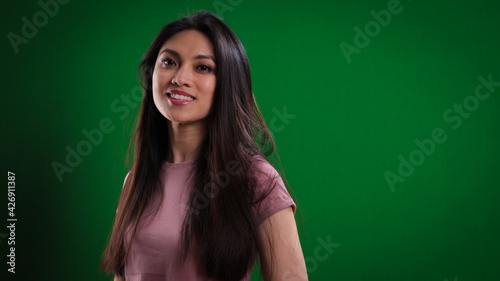 Young pretty woman in the studio posing against a green background - studio photography