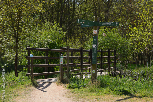 palo con indicador de caminos, pequeño puente de madera, mascarilla puesta al puente, malas costumbres en el campo, suciedad en el campo