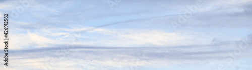 Φωτογραφία Streaky pastel clouds in early evening, shades of blue, gray, and white, as a na
