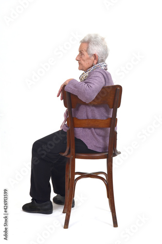 senior woman sitting on chair of profle on white background