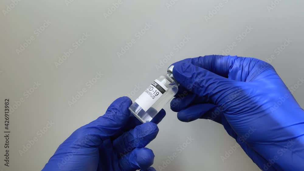 Doctor in blue gloves hold vaccine vial, coronavirus vaccination concept 4k tootage Doctor in blue gloves hold vaccine vial, coronavirus vaccination concept 4k tootage