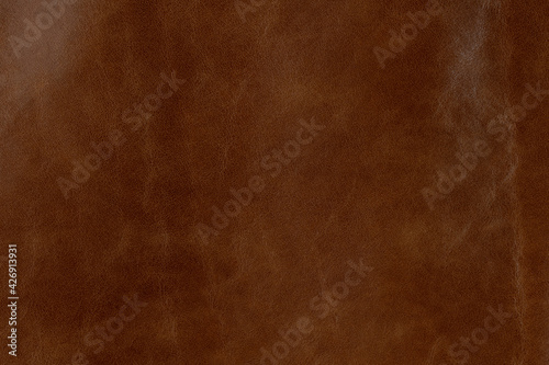 Brown textured smooth leather surface background, small grain