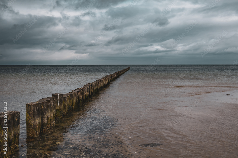 groynes on the beach of the Baltic Sea and the sky is dramatically cloudy groynes on the beach of the Baltic Sea and the sky is dramatically cloudy
