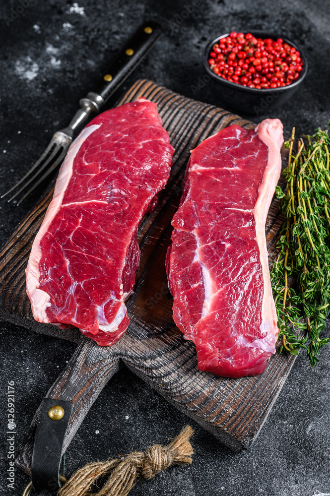 Raw marbled beef meat sirloin steak. Black background. Top view