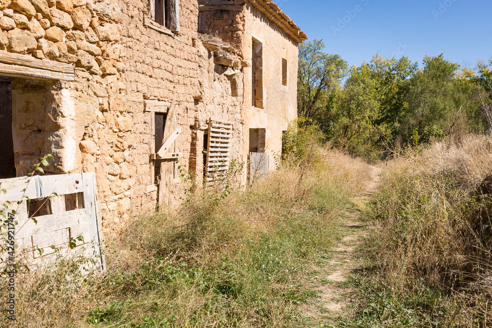 a rural path close to abandoned rustic houses in Navapalos (municipality of El Burgo de Osma), province of Soria, Castile and Leon, Spain