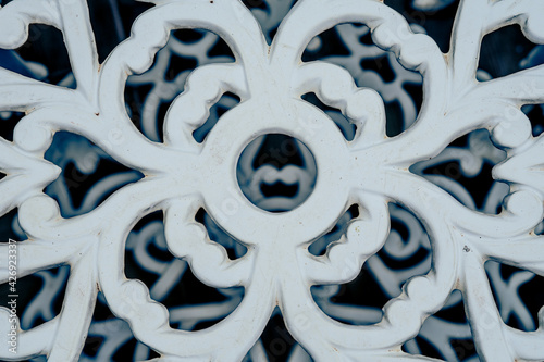 Metal flower pattern in a white chair.