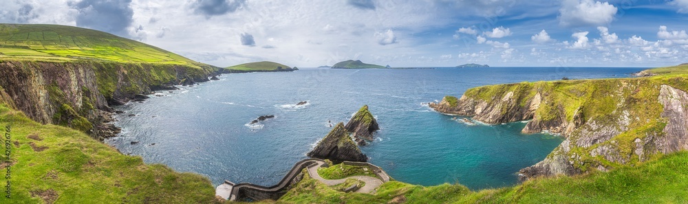 Beautiful panoramic shot of amazing Dunquin Pier and harbour with tall cliffs, turquoise water and islands, Dingle, Wild Atlantic Way, Kerry, Ireland