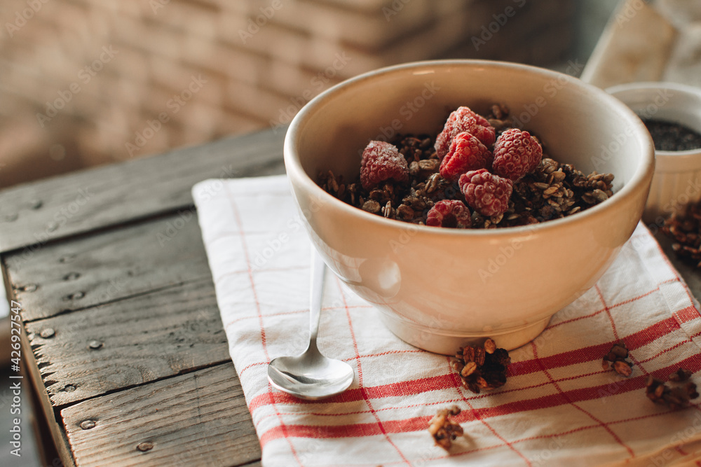 Delicious and healthy breakfast with raspberries. Morning aesthetics and beautiful layout on a wooden table. Granola for healthy breakfast. Delicious and healthy breakfast with raspberries. Morning aesthetics and beautiful layout on a wooden table. Granola for healthy breakfast.