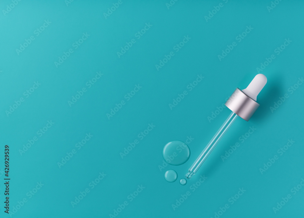 face serum drops on mint background, with empty space for text. face serum on mint background, with copy space for text. Top view. face serum drops on mint background, with empty space for text. face serum on mint background, with copy space for text. Top view.