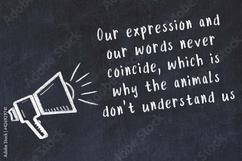 Chalk loudspeaker and wise quote on black desk