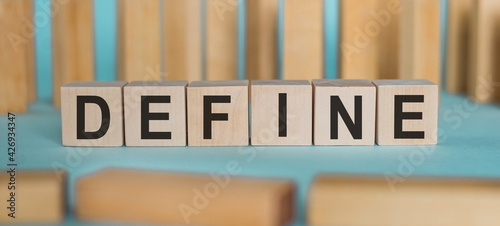 Konstfotografi DEFINE word written on wooden blocks on light blue background.