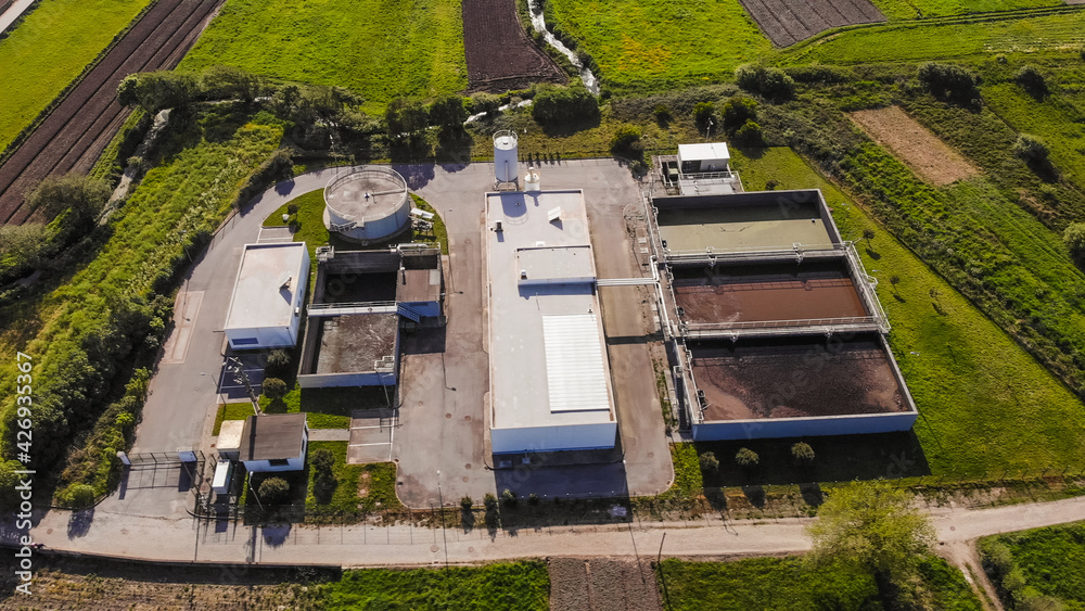 Aerial view of wastewater treatment plant, filtration of dirty or sewage water in Esposende, Portugal. Modern plant building and trickling filters for waste-water treatment.