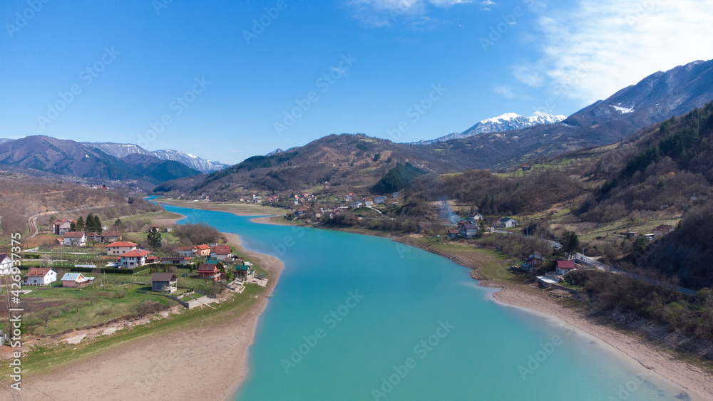 Aerial drone view of beautiful green river, hills and villages. Landscape. River Neretva, Konjic, Bosnia and Herzegovina.