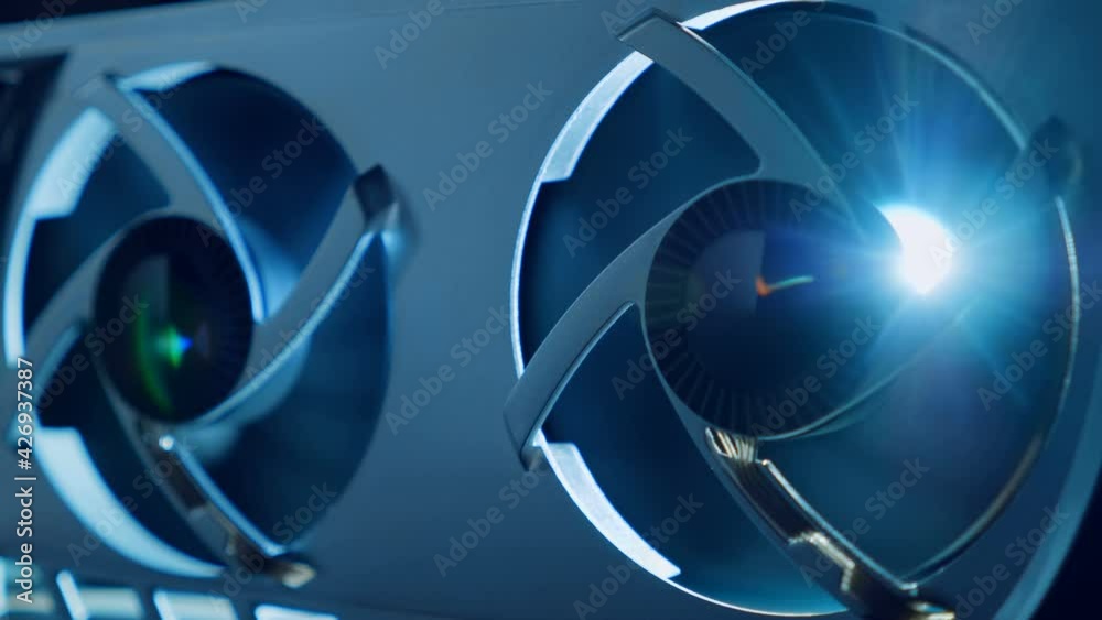 In the dark the cooling fans are spinning on the video card, light illuminates the coolers from the inside. Macro. Closeup