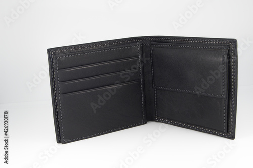 Open and empty men's wallet, black in color and isolated on white background.