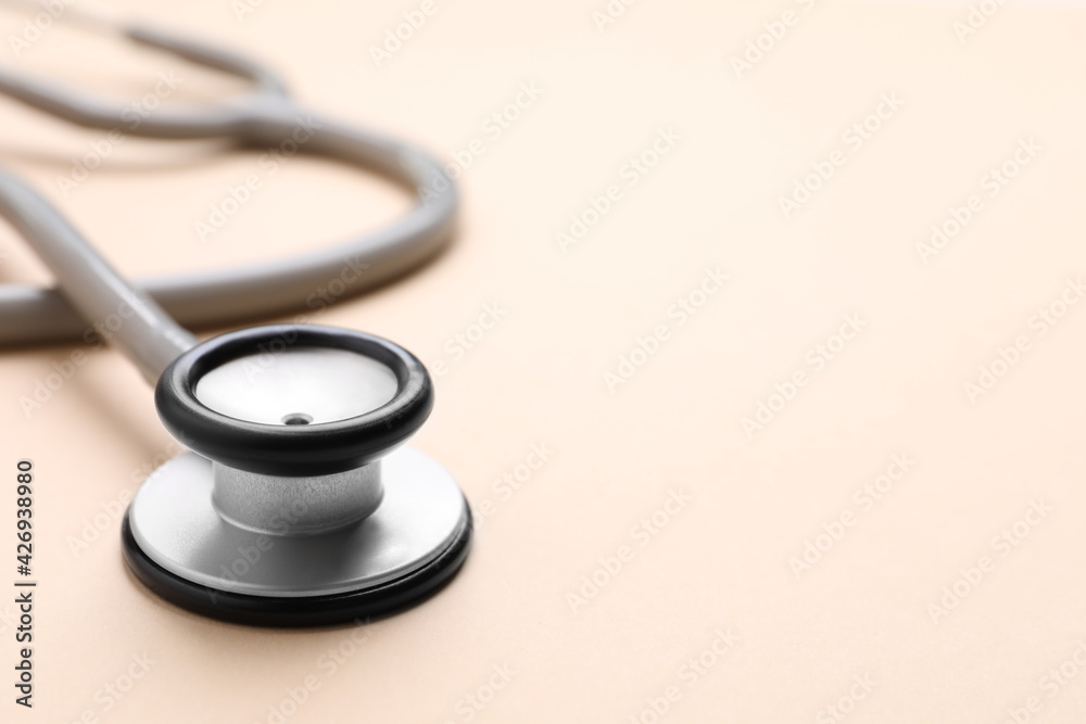 Stethoscope on beige background, closeup. Space for text Stethoscope on beige background, closeup. Space for text