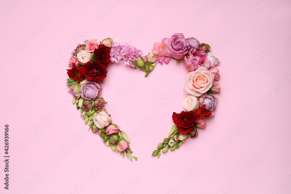 Beautiful heart shaped floral composition on pink background, flat lay