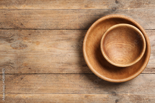 Empty clean wooden dishware on table, top view. Space for text