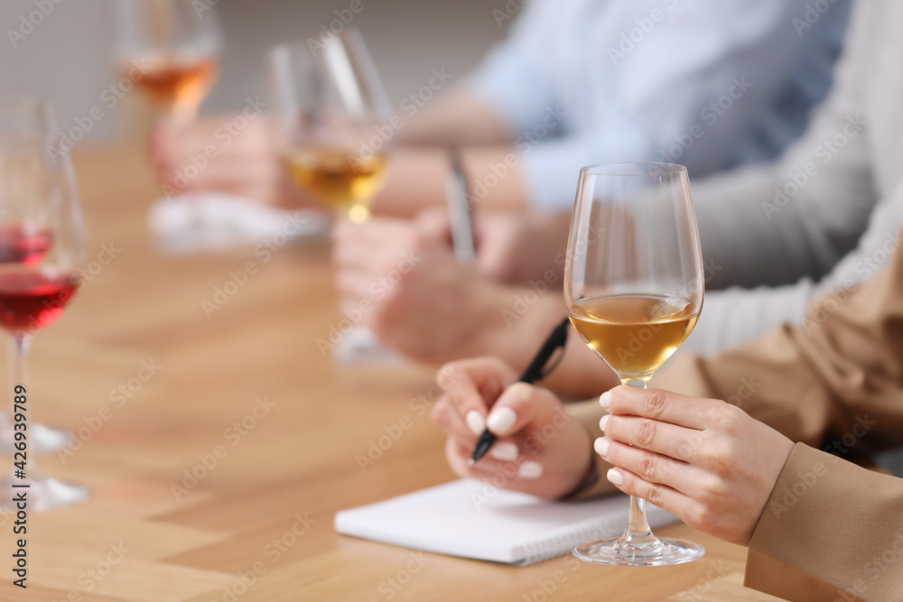 Sommeliers tasting different sorts of wine at table indoors, closeup Sommeliers tasting different sorts of wine at table indoors, closeup