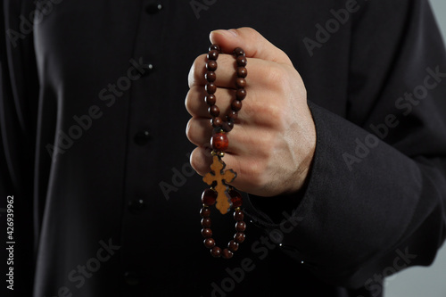 Priest in cassock with rosary beads, closeup