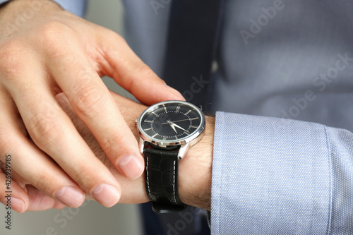 Man wearing luxury wrist watch with leather band, closeup