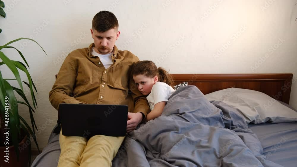 Focused young father with preschooler kid sit on bed at home using electronic devices not talking, modern dad with cute little daughter work on gadgets, play or surf internet. Device overuse concept Focused young father with preschooler kid sit on bed at home using electronic devices not talking, modern dad with cute little daughter work on gadgets, play or surf internet. Device overuse concept