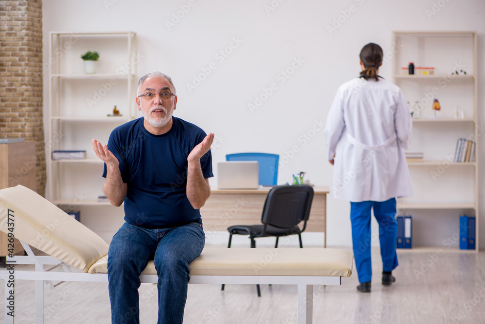 Fototapeta premium Old male patient visiting young male doctor