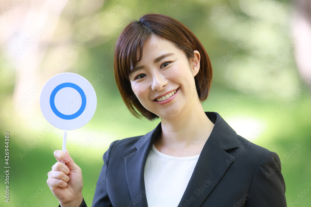 〇札を持つ女性社員イメージ