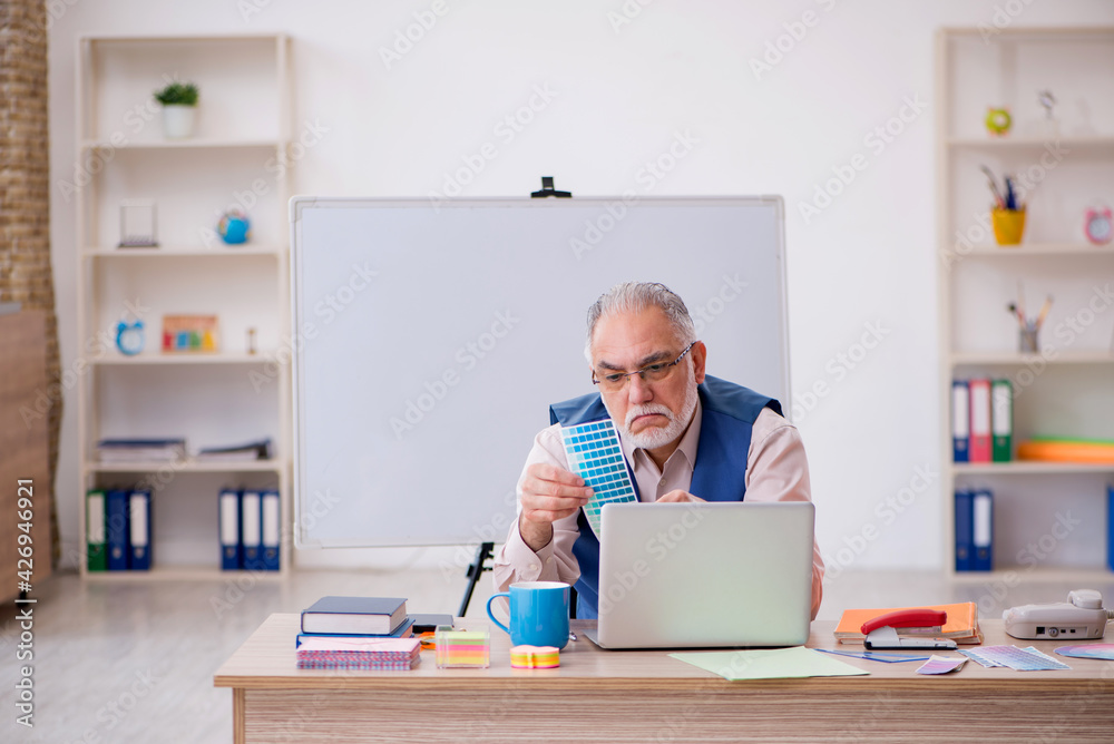 Old male designer working in the office