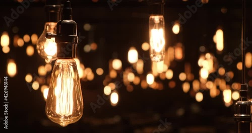 close up swaying retro light bulb with beautiful bokeh at dark night