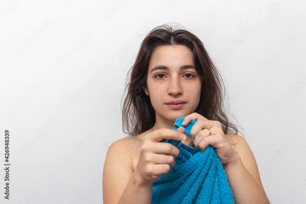 Woman wrapped in blue towel on white background Woman wrapped in blue towel on white background