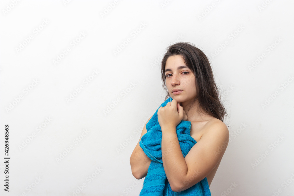 Woman wrapped in blue towel on white background Woman wrapped in blue towel on white background