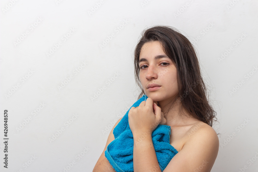 Woman wrapped in blue towel on white background Woman wrapped in blue towel on white background