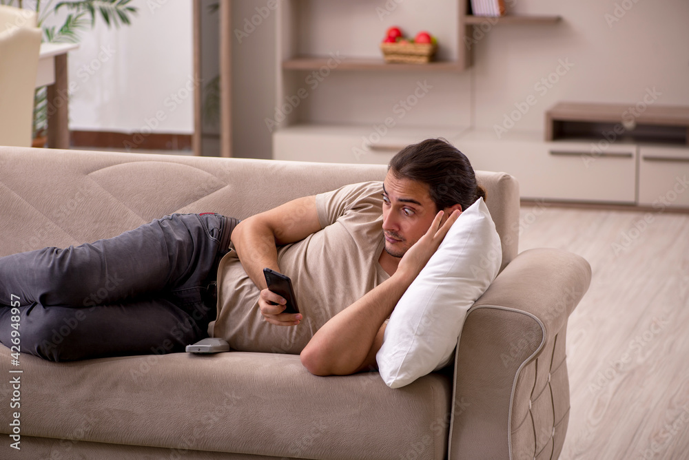 Young man lying on the sofa at home Young man lying on the sofa at home