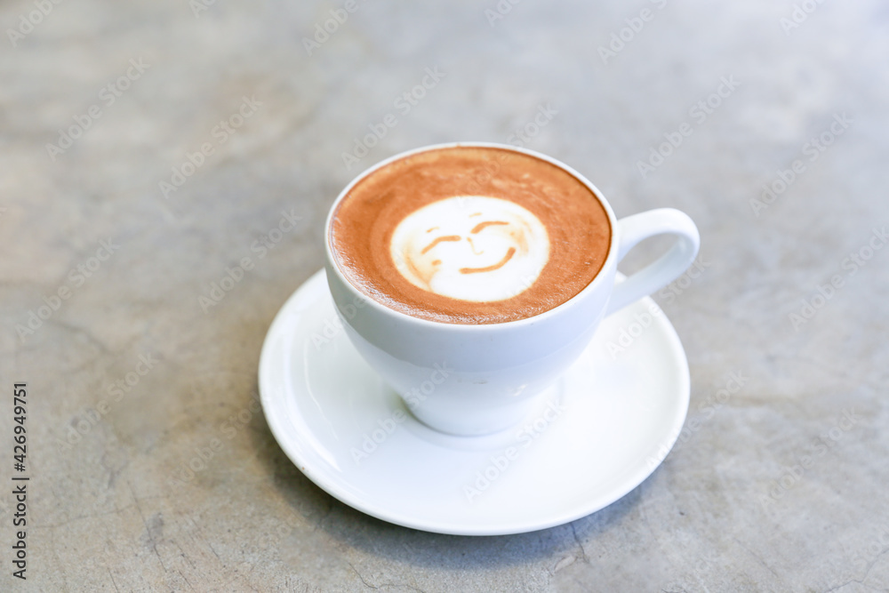 Fototapeta premium Cup of hot tasty cappucino with smile as art latte