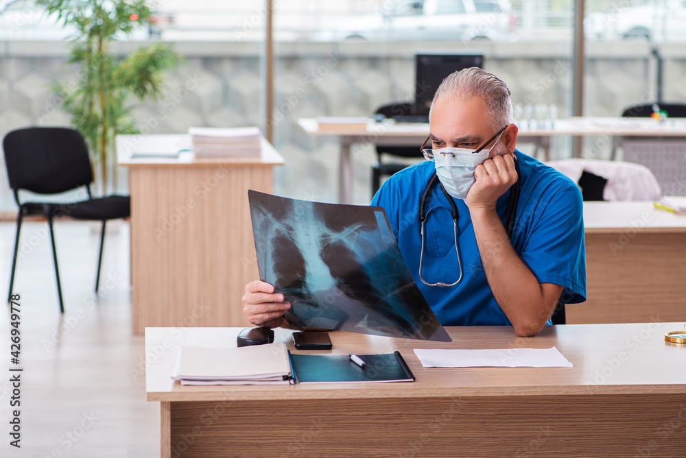 Old male doctor radiologist working in the clinic Old male doctor radiologist working in the clinic
