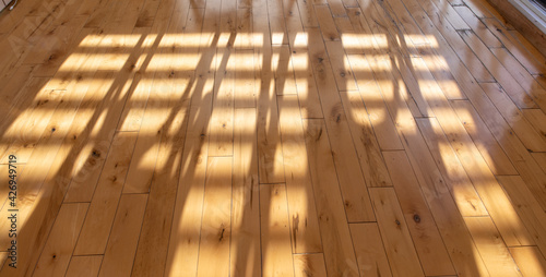 Vue d'un plancher de bois avec lumière du soleil créant un motif abstrait