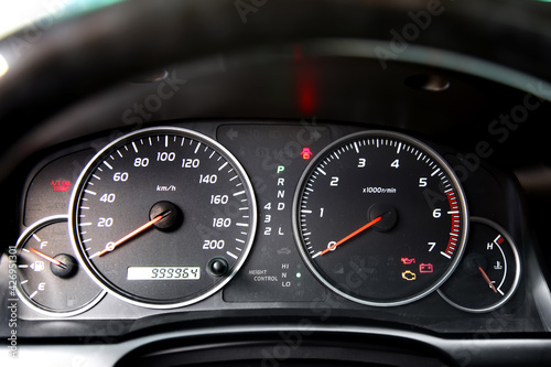 Car dashboard. Speedometer and tachometer close-up. The ignition is on. Control lamps and indicators are visible. 