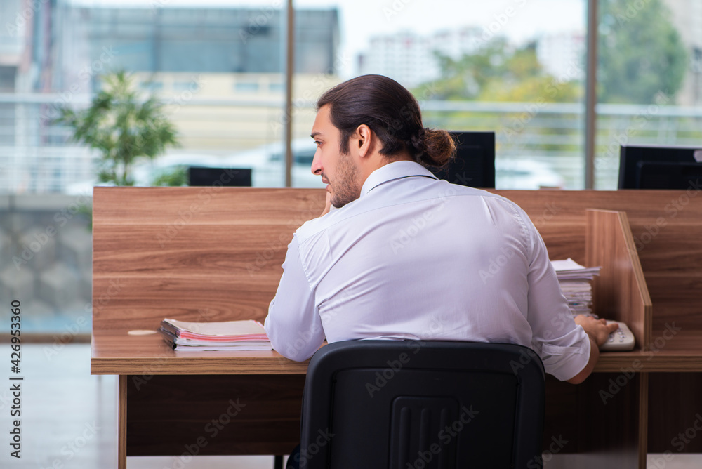 Young male employee and too many work in the office Young male employee and too many work in the office