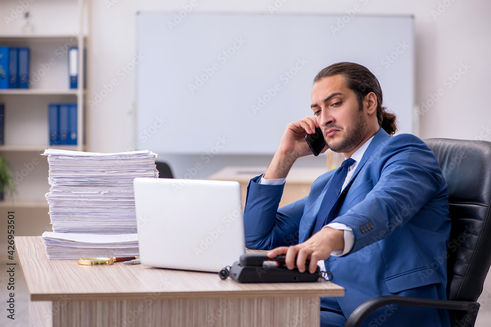 Young male employee and too much work in the office