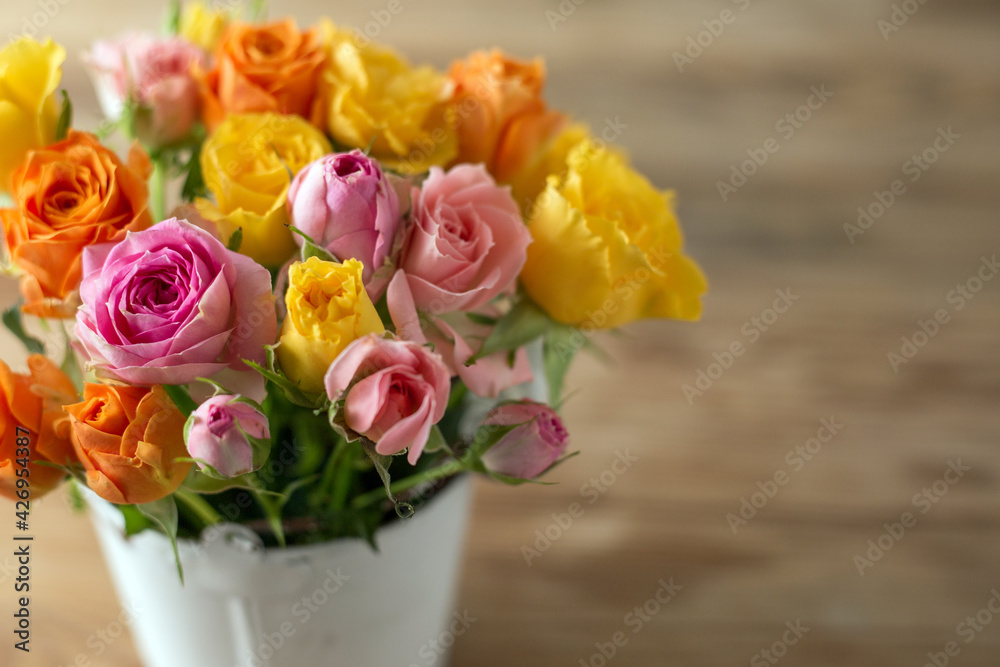 Beautiful pink, orenge and yellow roses flowers on old wooden table Beautiful pink, orenge and yellow roses flowers on old wooden table