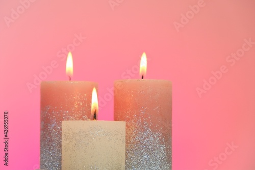 Candles set. Festive glitter candles on a pink background. Candle flame. 