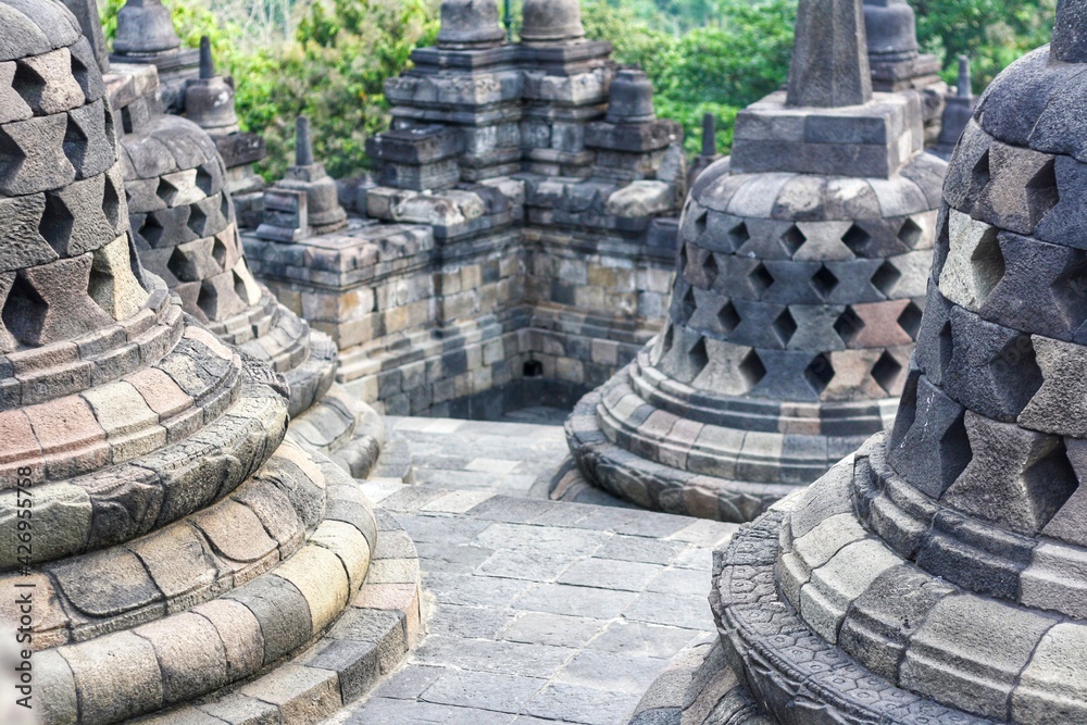 Interior of ancient Borobudur Temple. View of stupas on upper terrace. Popular tourist and Buddhist pilgrimage destination. No people. For wallpaper or background. 