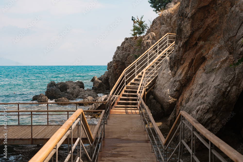 Wood stairs on a mountain road against the background of the sea and mountains