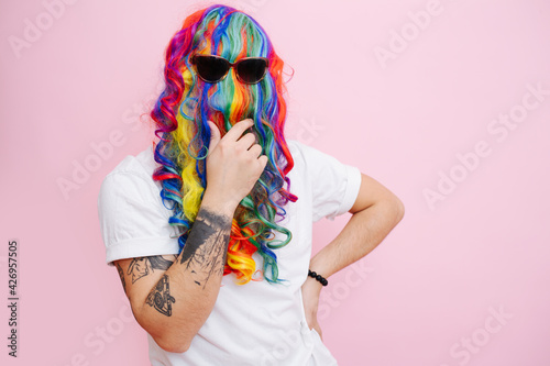 Fotografi Hilarious looking man in a wig over face and sunglasses stroking beard