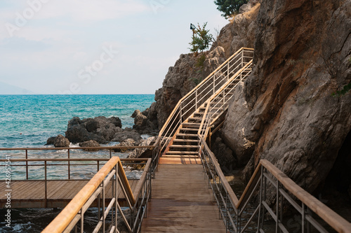 Wood stairs on a mountain road against the background of the sea and mountains