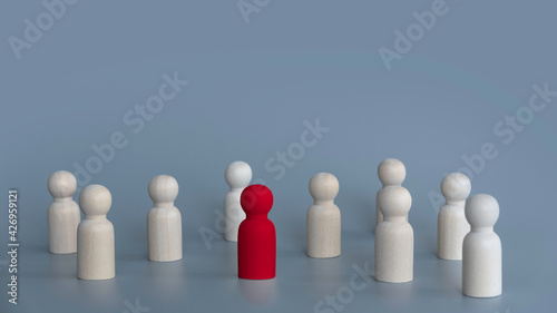 Concept of leader or boss in a team. Wooden people on gray background.