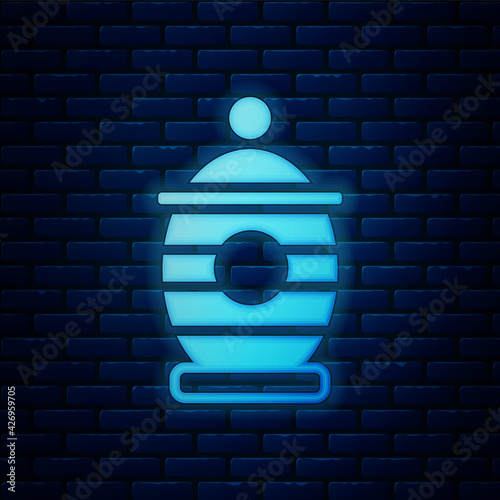 Glowing neon Funeral urn icon isolated on brick wall background. Cremation and burial containers, columbarium vases, jars and pots with ashes. Vector