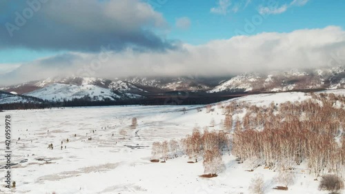 Beautiful view of snow-covered mountains and forest at sunrise. Aerial drone view. Early spring landscape of countryside. South Ural, Bashkortostan, Russia. 4k photo