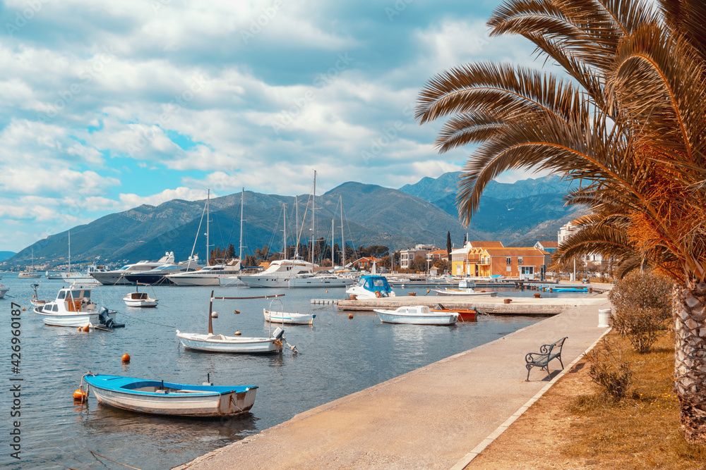 Beautiful Mediterranean landscape with village embankment and fishing boats on water. Montenegro, Adriatic Sea, view of Bay of Kotor  and Seljanovo village near Tivat city. Color toning